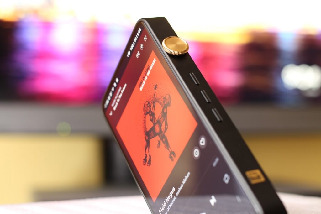 Um Telefone Celular Sentado Em Cima De Uma Mesa tCB_BOPfm9k