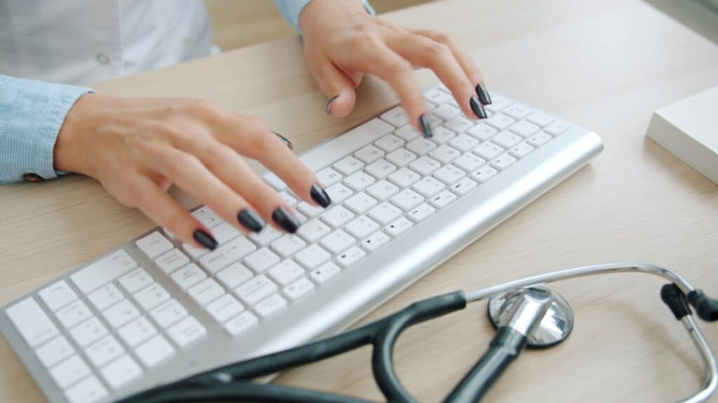 Doutor Que Datilografa No Teclado Com Estetoscopio Proximo FQQoUPVb_1c